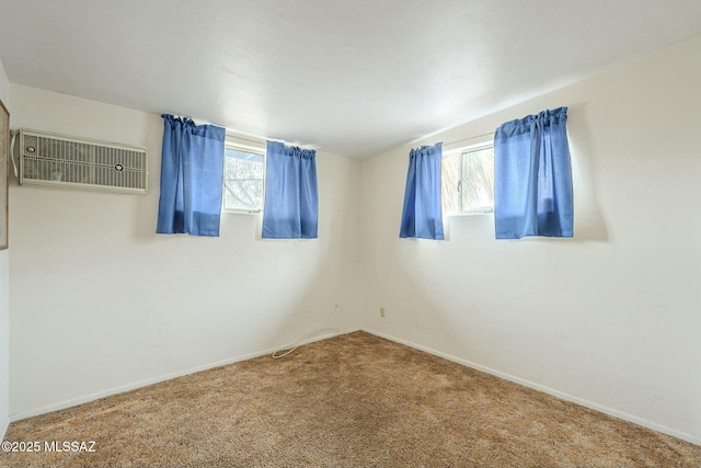 carpeted spare room with baseboards and a wall mounted air conditioner