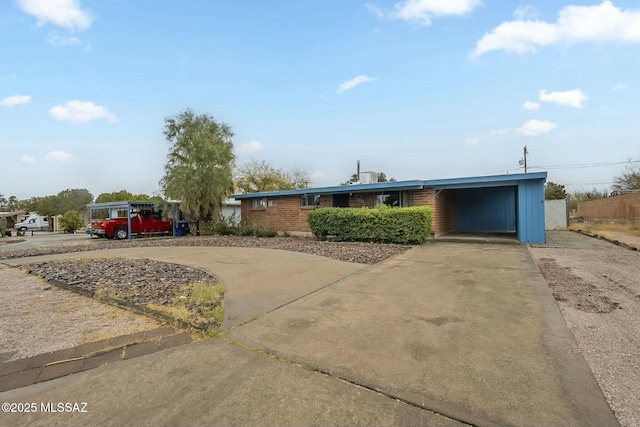 view of front of home with an attached carport, concrete driveway, and brick siding