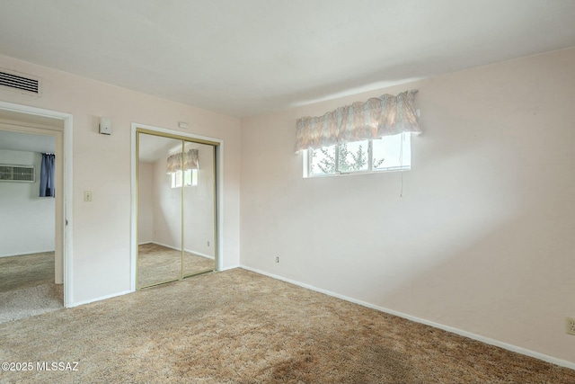 unfurnished bedroom with baseboards, a closet, visible vents, and carpet flooring