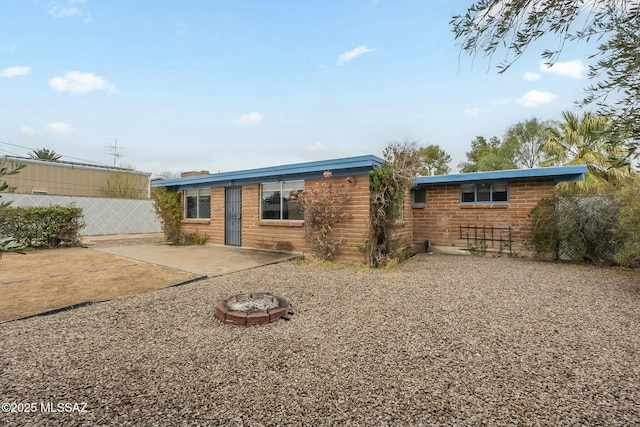 back of house featuring a patio area, fence, and brick siding