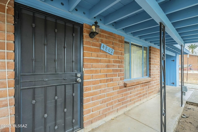 view of exterior entry featuring brick siding