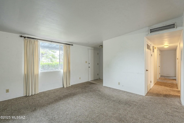 carpeted spare room featuring visible vents