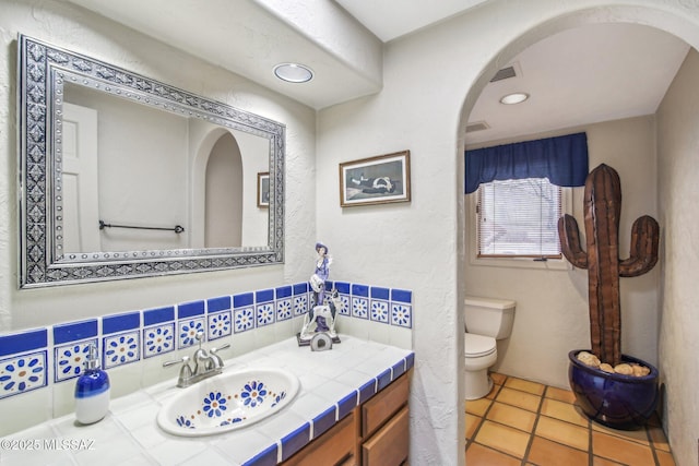 bathroom with vanity, tile patterned flooring, and toilet