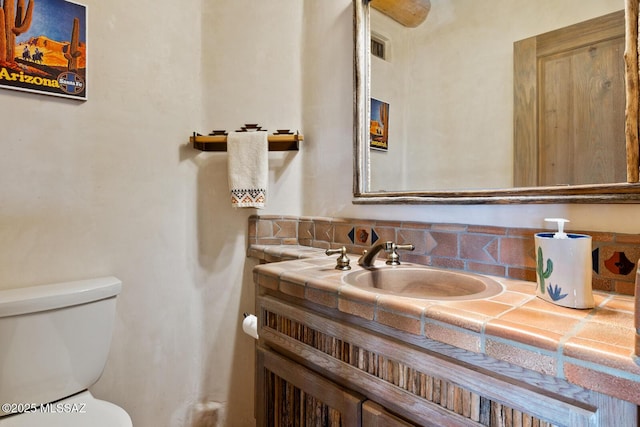 bathroom with vanity, toilet, and visible vents