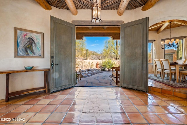 entrance foyer featuring a chandelier, light tile patterned floors, beamed ceiling, and wood ceiling