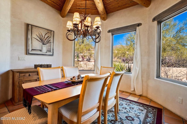 dining space with tile patterned flooring, beamed ceiling, wood ceiling, and a chandelier