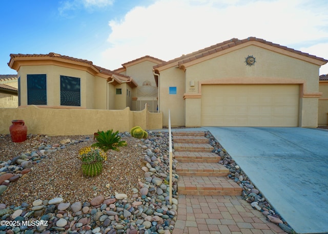 mediterranean / spanish house featuring driveway, a tile roof, an attached garage, fence, and stucco siding