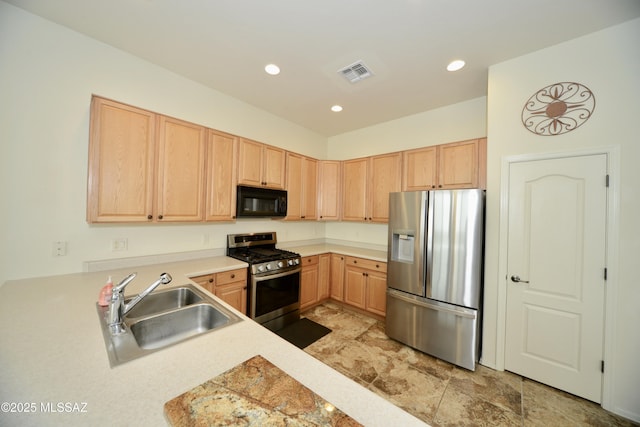 kitchen featuring stainless steel appliances, light brown cabinets, a sink, and visible vents