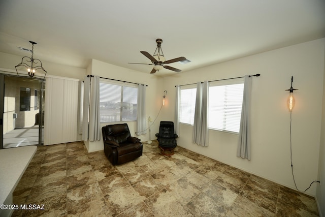 unfurnished room with visible vents and ceiling fan with notable chandelier