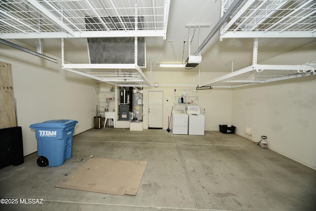 garage featuring independent washer and dryer, heating unit, and a garage door opener