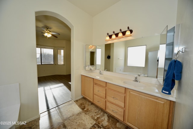 bathroom with double vanity, baseboards, a ceiling fan, and a sink