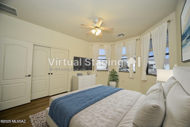 bedroom featuring a closet, dark wood finished floors, visible vents, and a ceiling fan