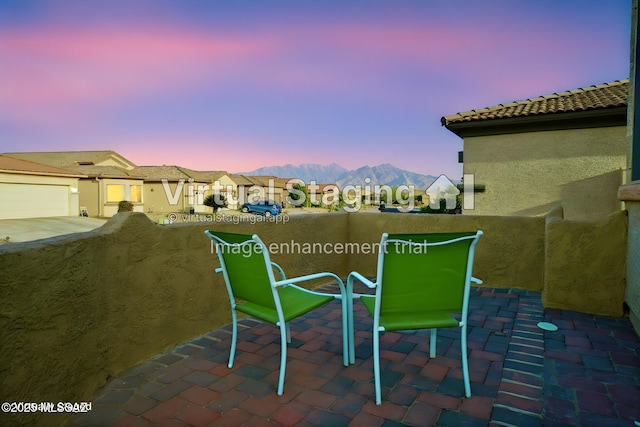 patio terrace at dusk featuring a mountain view