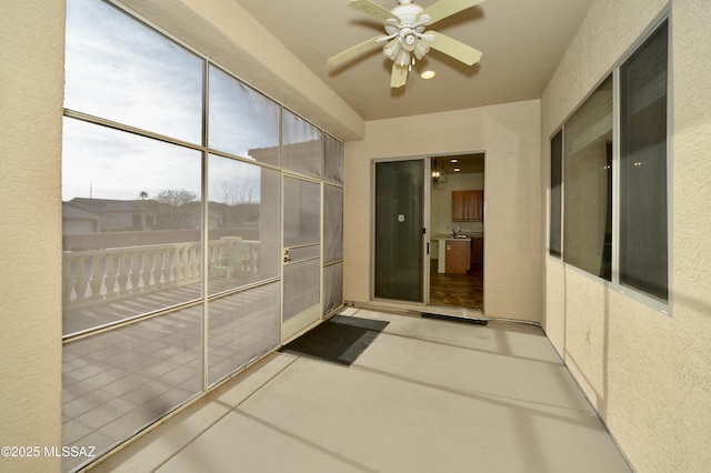 unfurnished sunroom with a ceiling fan