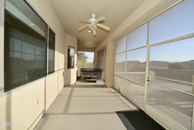 unfurnished sunroom with a ceiling fan