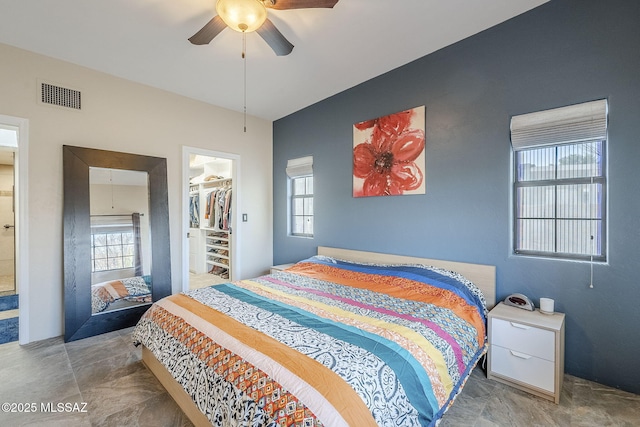 bedroom with a closet, visible vents, ceiling fan, and a spacious closet