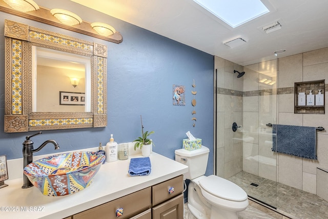 bathroom featuring toilet, visible vents, a tile shower, and vanity