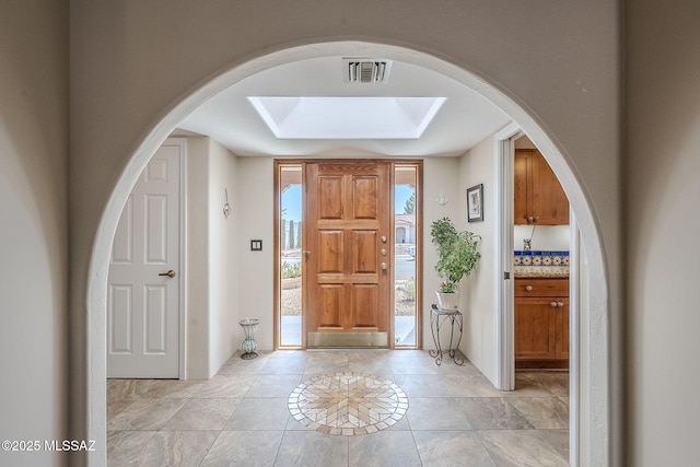 foyer featuring arched walkways and visible vents