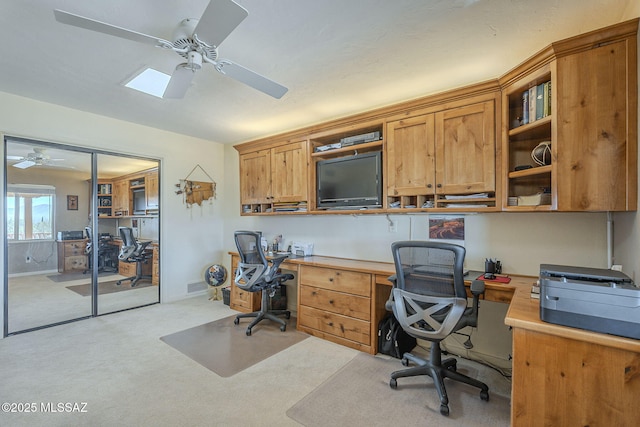 carpeted home office featuring ceiling fan