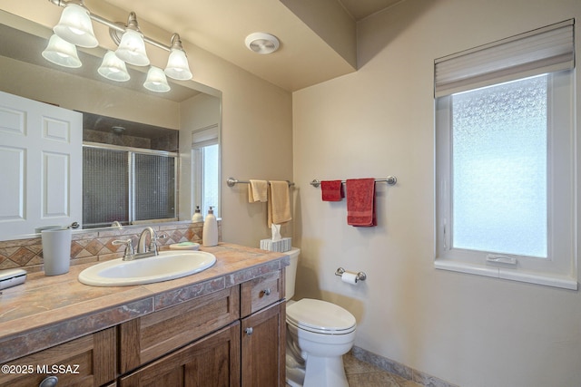 bathroom with tile patterned flooring, toilet, decorative backsplash, an enclosed shower, and vanity