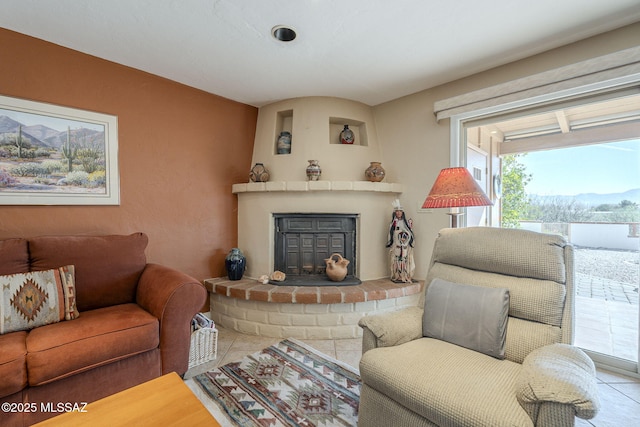 living room featuring a brick fireplace and a mountain view