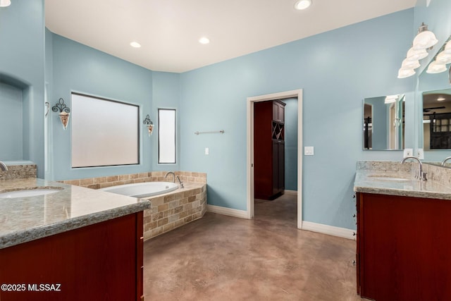 full bath with a bath, baseboards, two vanities, and a sink