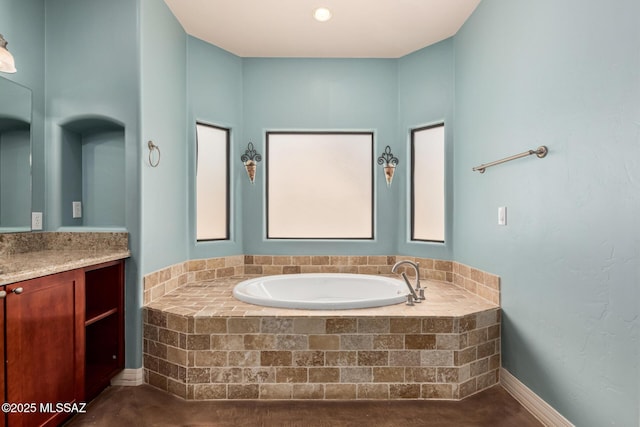 bathroom with a garden tub and vanity