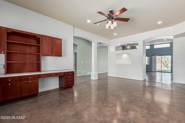 kitchen featuring concrete flooring, open floor plan, built in study area, and recessed lighting