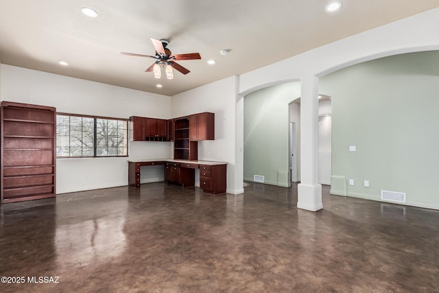 unfurnished living room featuring a ceiling fan, arched walkways, finished concrete flooring, and recessed lighting