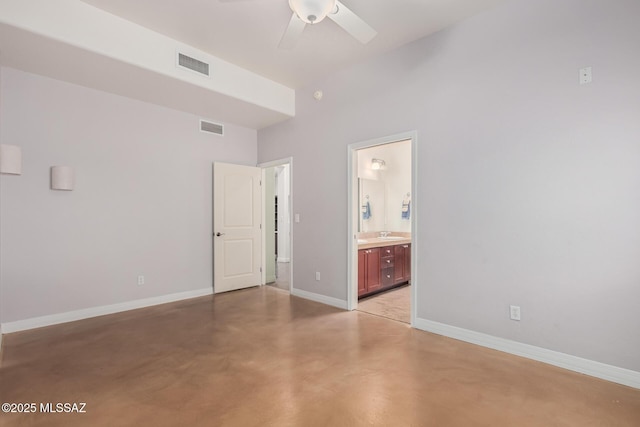 unfurnished bedroom featuring finished concrete flooring, ensuite bath, visible vents, and baseboards