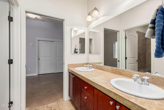 bathroom with double vanity, a sink, and baseboards