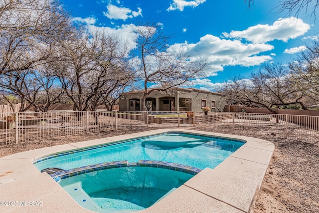 view of swimming pool featuring fence and a pool with connected hot tub