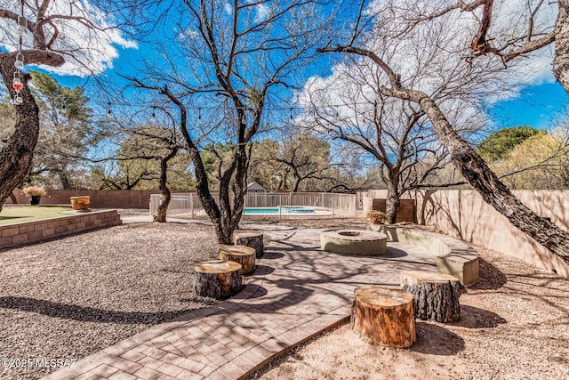 view of patio / terrace featuring a fenced in pool, a fenced backyard, and a fire pit