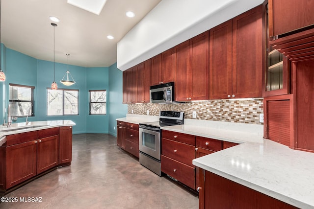 kitchen featuring stainless steel appliances, a sink, hanging light fixtures, decorative backsplash, and finished concrete floors