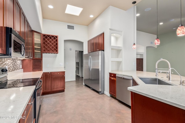 kitchen featuring stainless steel appliances, visible vents, a sink, and light stone countertops