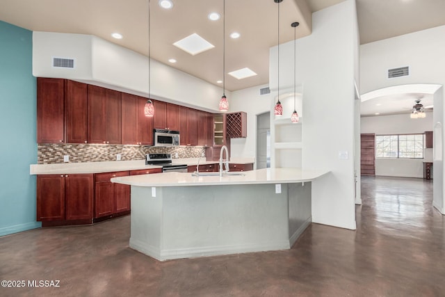 kitchen with stainless steel appliances, light countertops, concrete floors, open shelves, and a sink