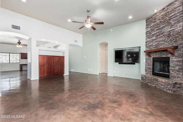 unfurnished living room with arched walkways, concrete floors, visible vents, and a ceiling fan