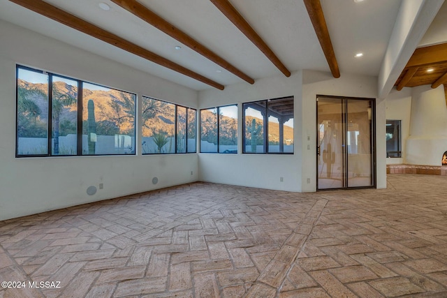 unfurnished room with beamed ceiling