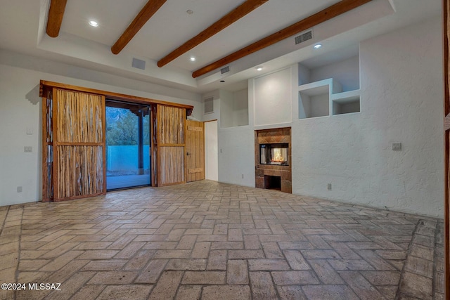 unfurnished living room featuring beamed ceiling and a towering ceiling