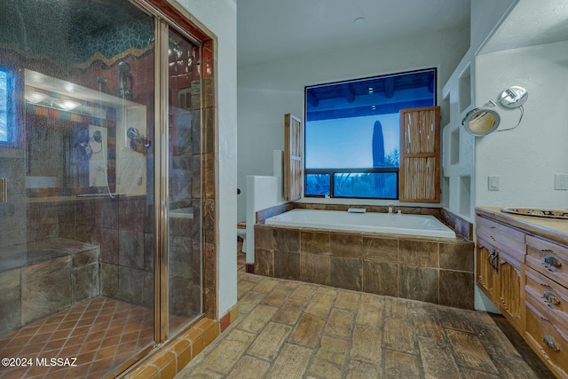 full bathroom featuring vanity, separate shower and tub, and toilet