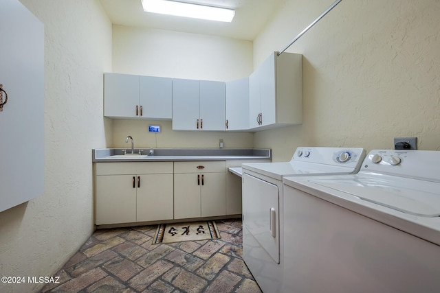 laundry room featuring cabinets, sink, and washer and clothes dryer