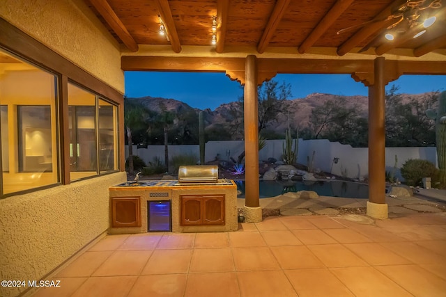 patio terrace at dusk featuring area for grilling and a mountain view