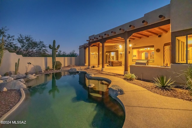 pool at dusk featuring a patio area