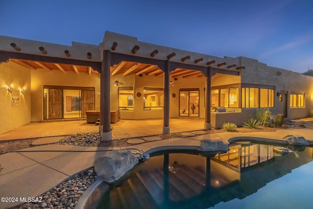 back house at dusk with a patio