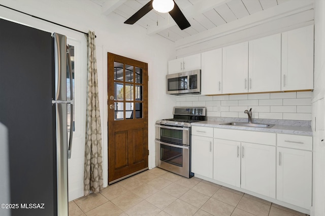 kitchen with white cabinetry, appliances with stainless steel finishes, light countertops, and a sink