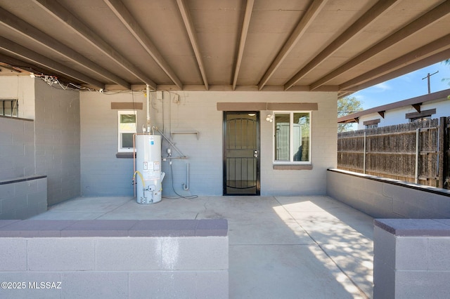 view of patio / terrace with water heater and fence