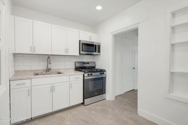 kitchen featuring open shelves, stainless steel appliances, light countertops, white cabinets, and a sink