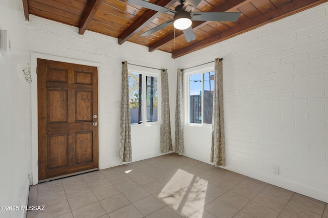 spare room with brick wall, beamed ceiling, light tile patterned flooring, and wood ceiling