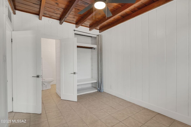 unfurnished bedroom featuring light tile patterned floors, wooden ceiling, beam ceiling, and a ceiling fan