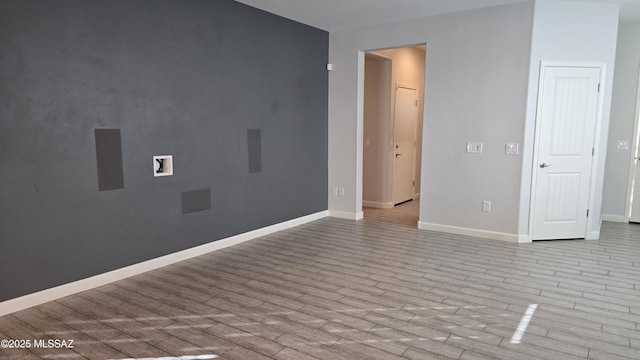 spare room featuring wood finished floors and baseboards